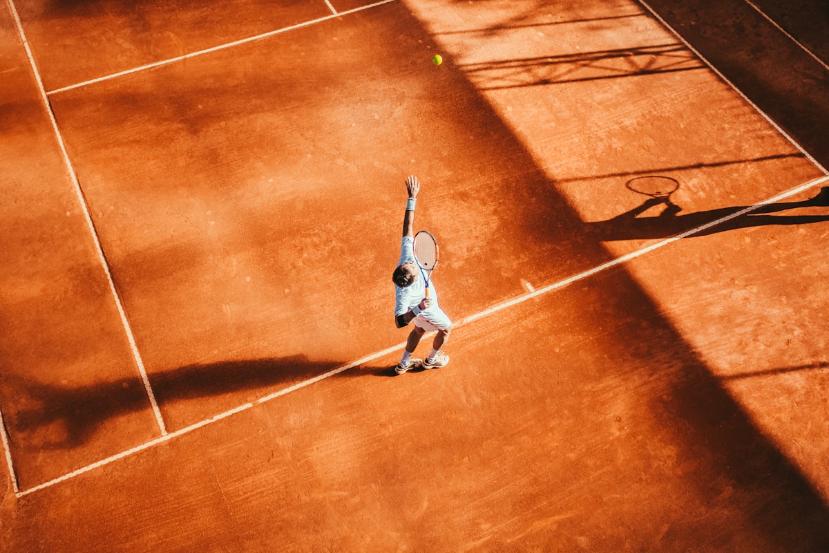 Joueur de tennis en extension sur terre battue